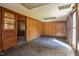 Basement with wood paneled walls, dropped ceiling, and stained concrete floor at 408 Rand Rd, Raleigh, NC 27603