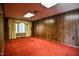 Red carpet and paneled walls outfit this finished basement area at 408 Rand Rd, Raleigh, NC 27603