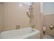 Bathtub and shower area with tile walls and vintage fixtures at 408 Rand Rd, Raleigh, NC 27603