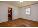 Bedroom with wood flooring and an open doorway into a kitchen with wooden cabinetry at 408 Rand Rd, Raleigh, NC 27603