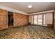 Bonus room with brick wall, patterned carpet, and sliding glass doors to the backyard at 408 Rand Rd, Raleigh, NC 27603