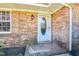 A covered front entrance features brick siding, a storm door and window at 408 Rand Rd, Raleigh, NC 27603