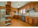 Functional kitchen with wooden cabinets, hardwood floors, and appliances at 408 Rand Rd, Raleigh, NC 27603