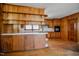 An additional shot of the kitchen shows a bar, cabinets, and wood paneling at 408 Rand Rd, Raleigh, NC 27603