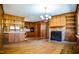 The living room and kitchen combination features wood paneling and a fireplace at 408 Rand Rd, Raleigh, NC 27603