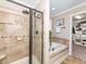 Modern bathroom with a glass shower, jacuzzi tub, and doorway to the walk-in closet at 424 Hocutt Farm Dr, Clayton, NC 27527