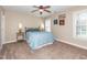 A bedroom with a window, ceiling fan, blue duvet, and a doorway to the hallway at 424 Hocutt Farm Dr, Clayton, NC 27527