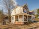Side view of a home with a welcoming porch, surrounded by a lush green lawn and mature trees at 424 Hocutt Farm Dr, Clayton, NC 27527