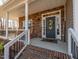 Cozy front porch featuring stone accents, rocking chairs, and a decorative front door at 424 Hocutt Farm Dr, Clayton, NC 27527