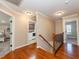 Upstairs hallway with hardwood floors leads to bedrooms and a laundry room with white appliances at 424 Hocutt Farm Dr, Clayton, NC 27527
