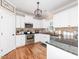 Well-lit kitchen features stainless steel appliances, granite countertops, and wooden floors at 424 Hocutt Farm Dr, Clayton, NC 27527