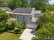 Aerial view of house with solar panels on the roof, lush landscaping, and a well-maintained lawn at 445 S Greensboro St, Carrboro, NC 27510