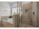 Relaxing bathroom featuring a soaking tub, tiled shower with glass doors, and a bright window at 445 S Greensboro St, Carrboro, NC 27510