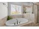 Relaxing bathroom featuring a soaking tub, walk-in shower, and natural light from a large window at 445 S Greensboro St, Carrboro, NC 27510