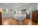 Cozy bedroom featuring large windows, neutral decor, and hardwood floors at 445 S Greensboro St, Carrboro, NC 27510