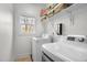 Neat laundry room with modern washer and dryer, plus shelving for storage at 445 S Greensboro St, Carrboro, NC 27510