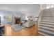 Bright living room featuring hardwood floors, fireplace, stairs, and large windows provide a cozy, inviting space at 445 S Greensboro St, Carrboro, NC 27510