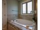 Relaxing bathroom with a luxurious soaking tub, tiled walls, and a bright window for natural light at 45 Carriden Dr, Youngsville, NC 27596