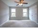 Bright, spacious bedroom with two windows, carpeted flooring, and a ceiling fan at 45 Carriden Dr, Youngsville, NC 27596