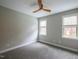Bright bedroom with two windows, gray carpet, ceiling fan, and neutral wall color at 45 Carriden Dr, Youngsville, NC 27596