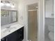 Bathroom featuring white cabinets, a large mirror and a walk in shower at 4601 Pemberton Dr, Raleigh, NC 27609