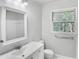 Clean bathroom featuring a white vanity, large mirror, and a window for natural light at 4601 Pemberton Dr, Raleigh, NC 27609
