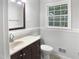 Cozy bathroom featuring white walls, a stained vanity with a sink, and a window providing natural light at 4601 Pemberton Dr, Raleigh, NC 27609