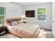 Cozy bedroom with natural light, a modern bed frame, and a mounted television at 4601 Pemberton Dr, Raleigh, NC 27609