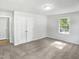 Bedroom featuring neutral carpet, white walls, a window, and a double door closet at 4601 Pemberton Dr, Raleigh, NC 27609
