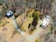 Aerial view of the property, featuring a metal garage/outbuilding, with a long gravel driveway at 471 Deer Run, Pittsboro, NC 27312