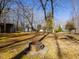Backyard with fire pit surrounded by trees and outbuildings in the distance at 471 Deer Run, Pittsboro, NC 27312
