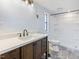 Bathroom features a sleek vanity with dark wood cabinets and a modern shower with white tile and updated fixtures at 471 Deer Run, Pittsboro, NC 27312