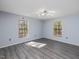 Bright bedroom with wood-look floors, two windows, and contemporary lighting at 471 Deer Run, Pittsboro, NC 27312