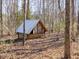 Exterior view of a small cabin surrounded by woods at 471 Deer Run, Pittsboro, NC 27312