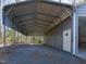 Metal carport with gravel floor and door leading to the exterior of the shed at 471 Deer Run, Pittsboro, NC 27312