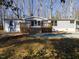 Charming single-story home featuring a wood deck and mature trees surrounding the property at 471 Deer Run, Pittsboro, NC 27312