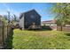 A spacious backyard featuring a well-maintained lawn and a wooden deck with a yellow door at 613 Canal St, Durham, NC 27701