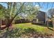 Backyard featuring a wooden fence, lush grass, mature tree, and modern two-story house at 613 Canal St, Durham, NC 27701