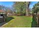Spacious, fenced backyard featuring green grass and shade, with a deck for outdoor relaxation at 613 Canal St, Durham, NC 27701