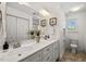Well-lit bathroom with double vanity, a large mirror, and a storage closet at 613 Canal St, Durham, NC 27701