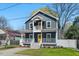 Charming two-story home featuring a welcoming front porch, upstairs balcony, and sunny yellow doors at 613 Canal St, Durham, NC 27701