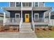 Inviting home featuring a bright yellow front door and a charming white railed porch at 613 Canal St, Durham, NC 27701