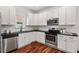 Modern kitchen with stainless steel appliances, ample cabinet space, and granite countertops at 613 Canal St, Durham, NC 27701