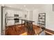 Bright modern kitchen featuring stainless steel appliances, white cabinets, and a breakfast bar at 613 Canal St, Durham, NC 27701