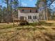 The house's backyard with a small deck in a partially wooded area on a sunny day at 6233 Reagan Ln, Wake Forest, NC 27587