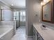 Bathroom featuring double vanity sinks, a soaking tub, and a glass enclosed shower at 6233 Reagan Ln, Wake Forest, NC 27587