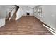 Open-concept living room showcases wood floors, a stone fireplace, and staircase to upper level at 6233 Reagan Ln, Wake Forest, NC 27587