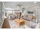 Sunlit living room featuring a gray sofa, stylish furniture, and an open floor plan that connects to the kitchen at 6233 Reagan Ln, Wake Forest, NC 27587