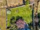 Aerial view of a home's large, green, fenced backyard with mature trees and flowering plants at 6817 Osprey Landing Dr, Wendell, NC 27591