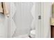 A well-lit bathroom featuring a toilet and a stylish striped shower curtain at 6817 Osprey Landing Dr, Wendell, NC 27591